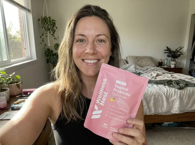 Authentic customer holding FloraFresh Vaginal Probiotics Gummies in matte pastel-pink stand-up pouch